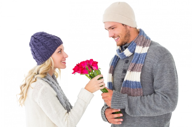 Uomo attraente in moda inverno che offre rose alla fidanzata