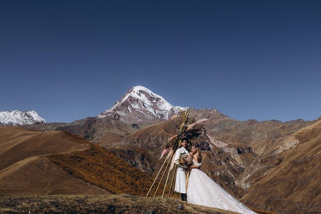 uomo attraente in un costume nazionale georgiano e sposa in un abito sofisticato