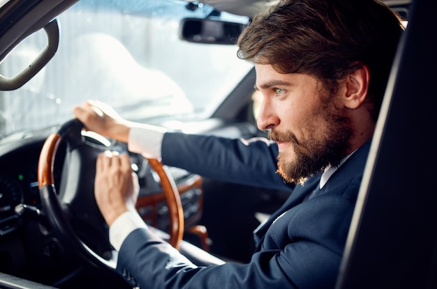 Uomo barbuto alla guida di un viaggio in auto stile di vita di lusso ricco