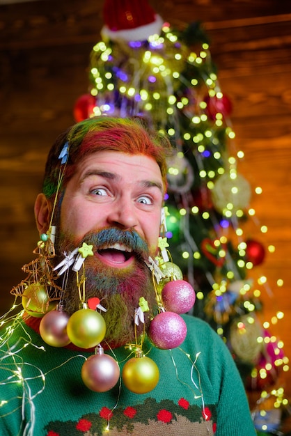 Uomo barbuto allegro con barba decorata festa di capodanno decorazioni per la barba di natale vacanze invernali