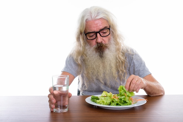 uomo barbuto anziano che indossa occhiali con acqua di vetro