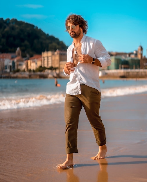 Uomo barbuto bello in spiaggia