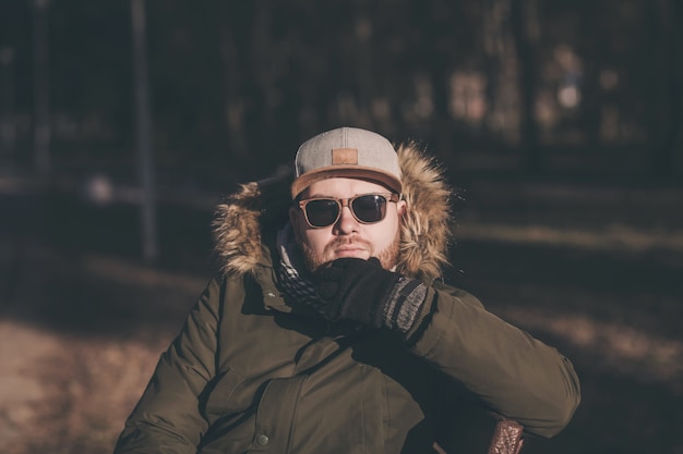 Uomo barbuto bello in una giacca invernale e un cappello