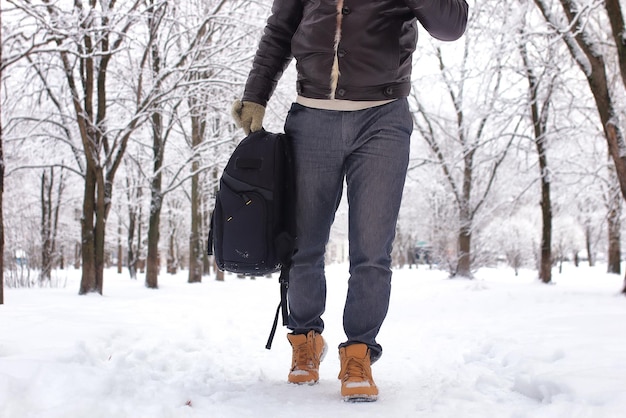 Uomo barbuto che cammina in una stagione di neve del parco invernale