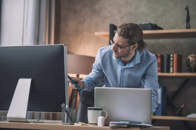 Uomo barbuto che lavora al computer portatile