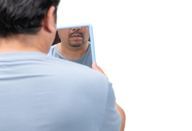 Uomo barbuto che si guarda allo specchio per etichette cutanee o acrochordon sul collo