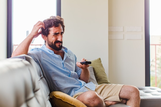 Uomo barbuto che si sente perplesso e confuso, grattandosi la testa