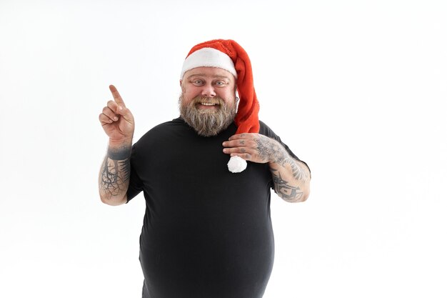 Uomo barbuto che sorride e che porta il cappello di Natale