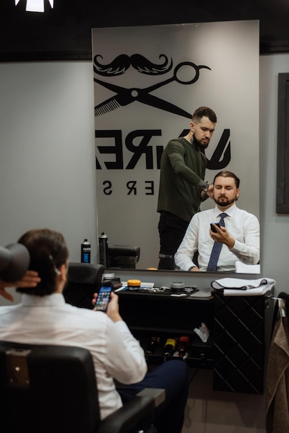 Uomo barbuto che taglia la barba nel barbiere