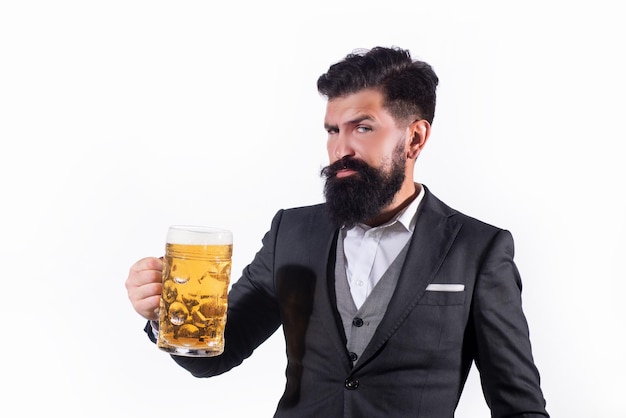 Uomo barbuto che tiene un bicchiere di birra hipster con barba e baffi in tuta beve birra dopo il lavoro