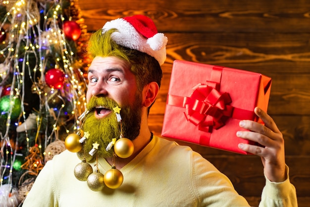 Uomo barbuto con cappello da Babbo Natale e regalo