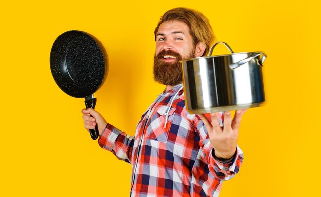 Uomo barbuto con casseruola e padella shopping utensili da cucina utensili da cucina per cibo sano