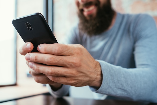 Uomo barbuto con il telefono