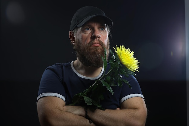 uomo barbuto e brutale con un fiore