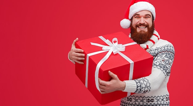 Uomo barbuto felice in cappello della Santa che tiene scatola luminosa