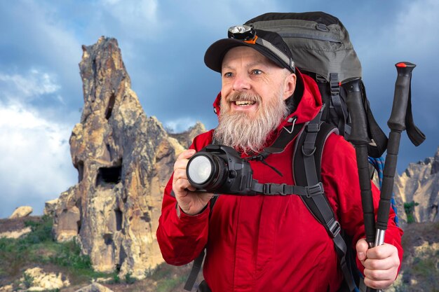 uomo barbuto fotografo turistico con uno zaino fotografa la bellezza della natura