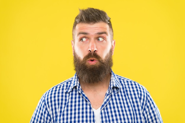 Uomo barbuto hipster chiedendosi faccia sfondo giallo primo piano. Guy ha sorpreso l'espressione del viso. Hipster con barba e baffi espressione sorpresa emotiva. Macho sorpreso rustico. Notizie sorprendenti.