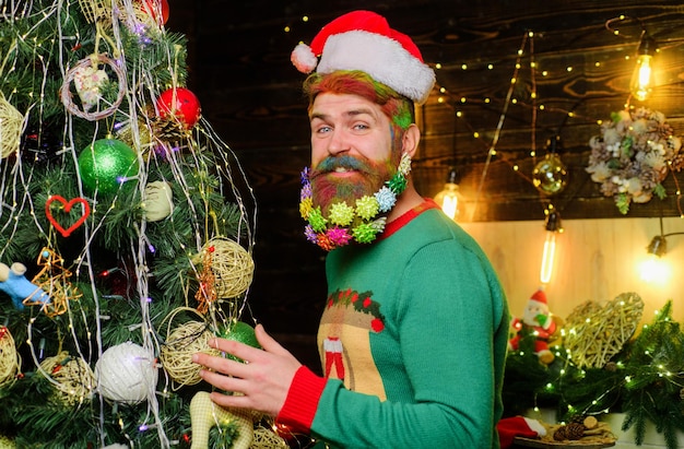 Uomo barbuto in cappello di Babbo Natale vicino all'albero di natale decorazioni per la barba di natale di felice anno nuovo