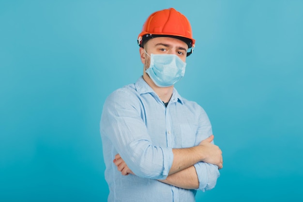 uomo barbuto in un casco protettivo arancione e maschera su sfondo blu