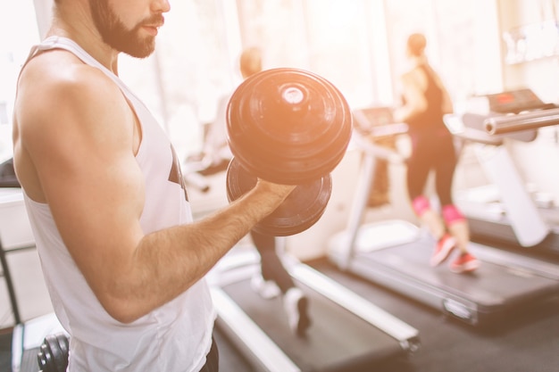 Uomo barbuto muscolare durante l'allenamento in palestra