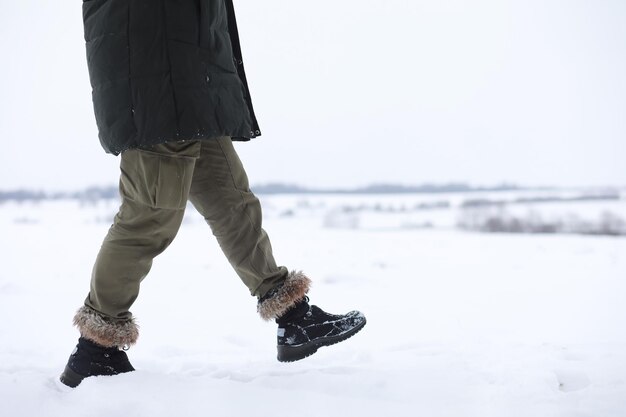 Uomo barbuto nei boschi invernali. Attraente giovane felice con la barba a piedi nel parco.