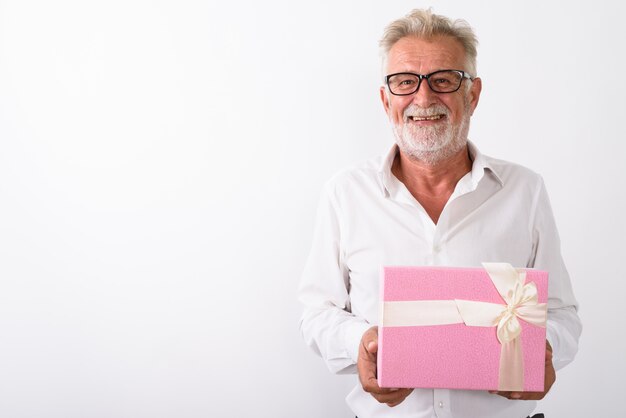 uomo barbuto senior felice che sorride mentre tiene il contenitore di regalo con gli occhiali su bianco