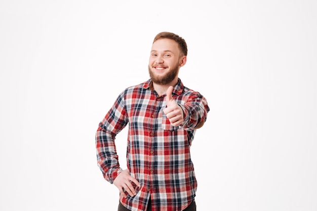 Uomo barbuto sorridente in camicia che mostra pollice in su