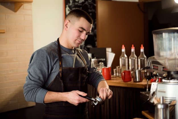 Uomo barista fare un caffè al bar.