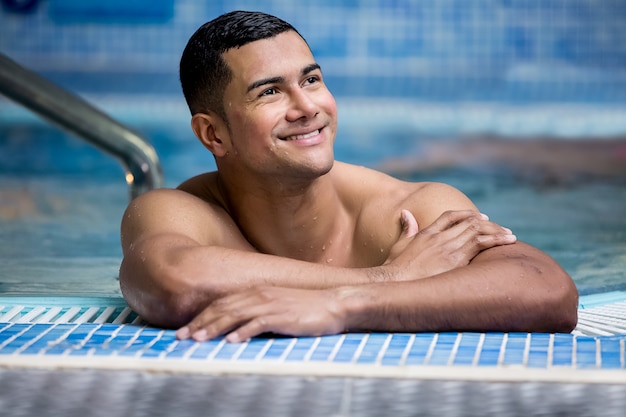 Uomo bello allegro in piscina