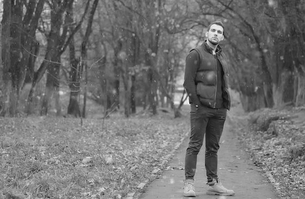 Uomo bello barba nel parco autunnale in posa sulla macchina fotografica