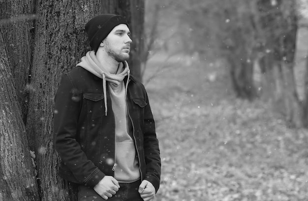 Uomo bello barba nel parco autunnale in posa sulla macchina fotografica