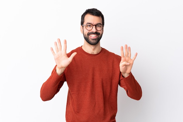 Uomo bello caucasico con la barba sopra bianco che conta nove con le dita