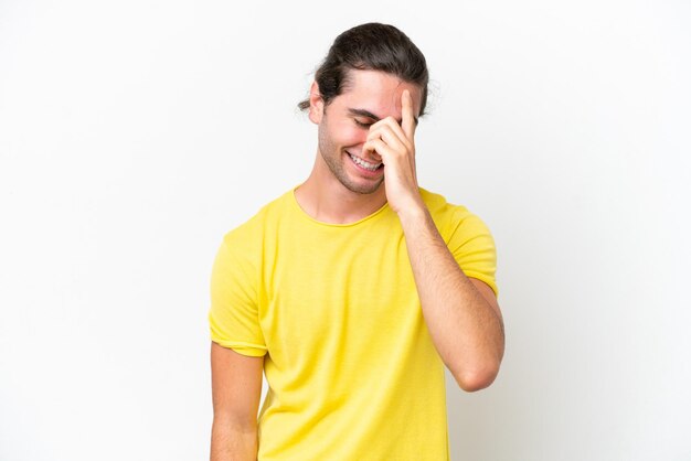 Uomo bello caucasico isolato su sfondo bianco ridendo