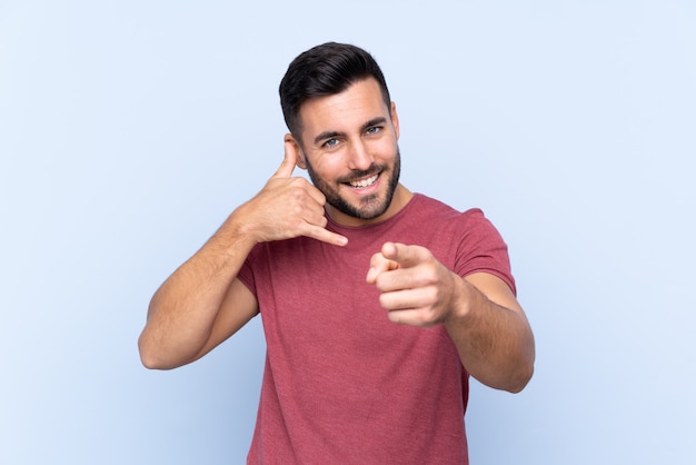 Uomo bello caucasico sopra la parete blu