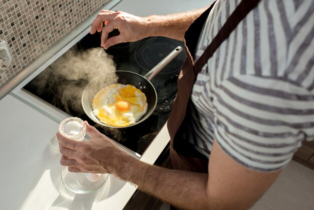 Uomo bello che cucina nella cucina