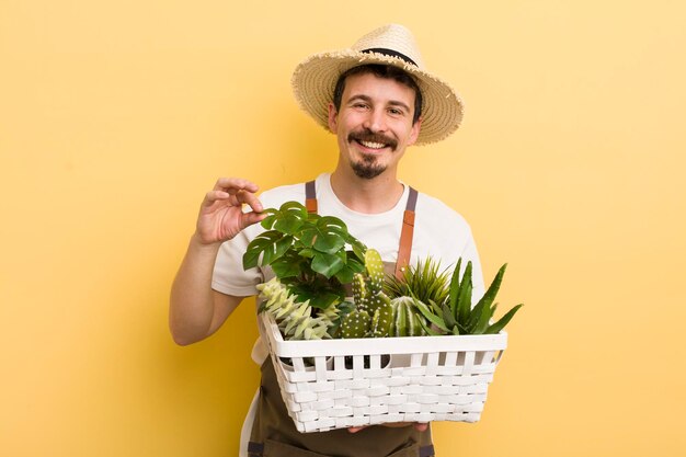 Uomo bello che fa il giardinaggio con le piante