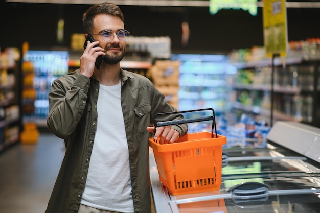 Uomo bello che fa shopping in un supermercato