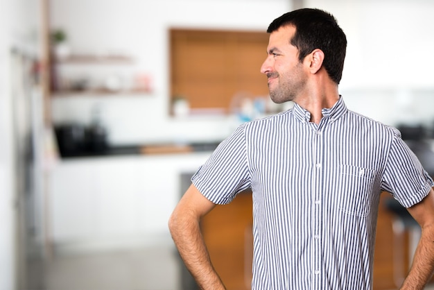 Uomo bello che guarda lateralmente all&#39;interno della casa