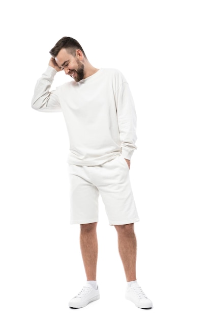 Uomo bello che indossa t-shirt bianca a maniche lunghe e pantaloncini isolati su sfondo bianco