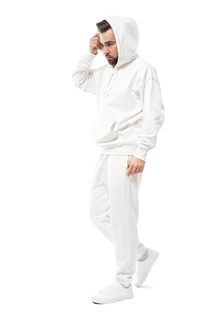 Uomo bello che indossa una felpa con cappuccio bianca vuota e pantaloni isolati su sfondo bianco