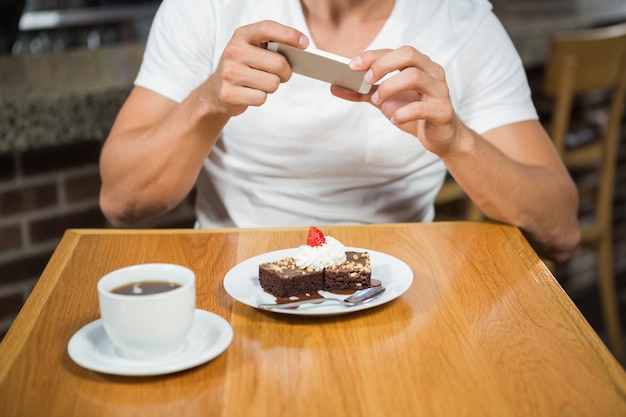 Uomo bello che prende un'immagine del suo alimento