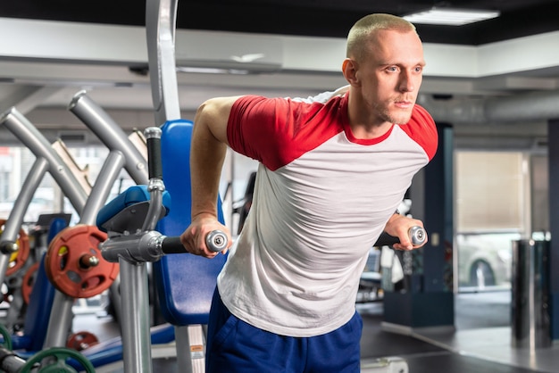 Uomo bello che risolve nella palestra di forma fisica