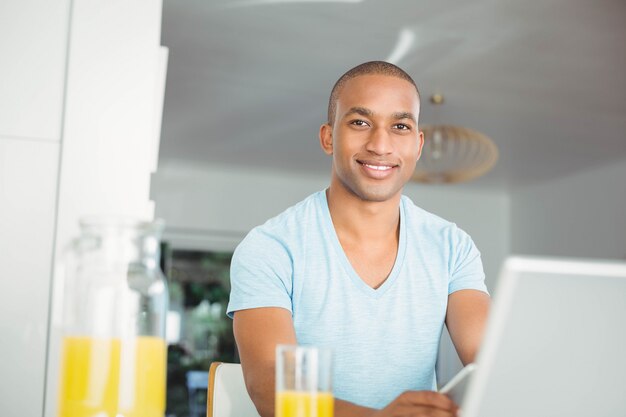 Uomo bello che sorride alla macchina fotografica nella cucina