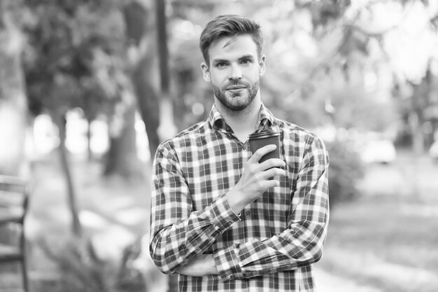 Uomo bello che tiene la tazza di carta con il ragazzo del caffè da asporto che beve il tè caldo del caffè del mattino in qualsiasi condizione atmosferica bevanda del buongiorno uomo d'affari fiducioso ha bisogno di ispirazione