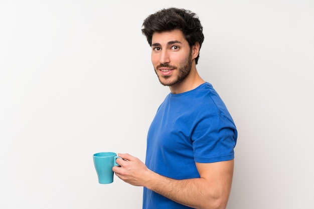 Uomo bello che tiene tazza di caffè calda