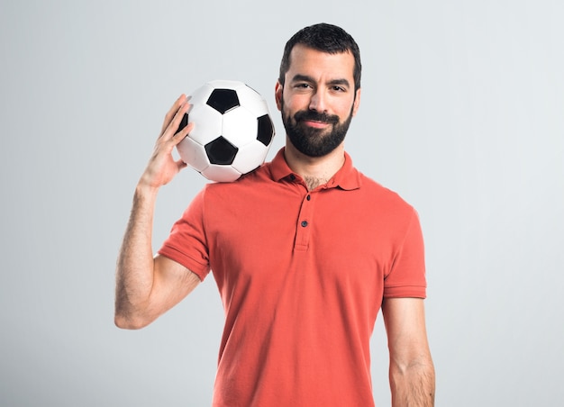 Uomo bello che tiene una pallina da calcio