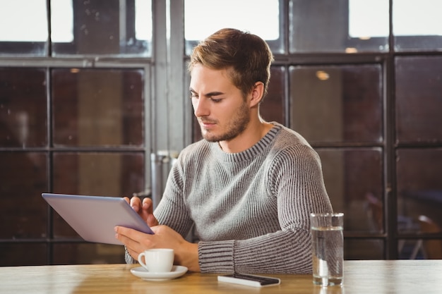 Uomo bello che tocca sul tablet PC