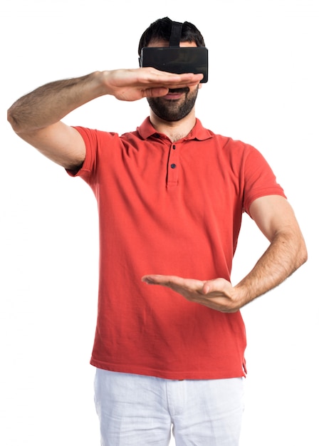 Uomo bello che usa VR glassesa e tiene qualcosa