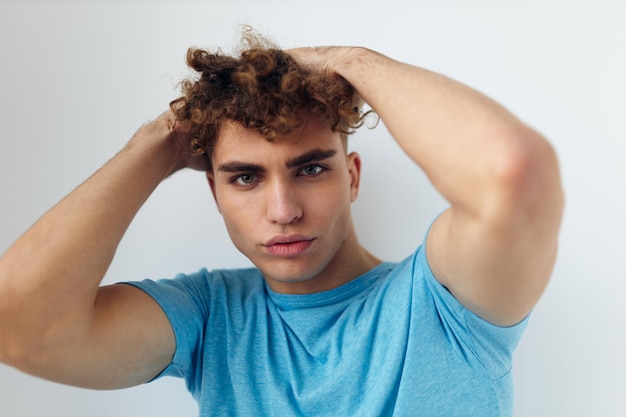 Uomo bello con i capelli ricci in una maglietta blu