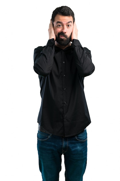 Uomo bello con la barba che copre le sue orecchie su fondo bianco